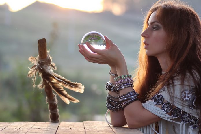 witch with crystal ball at sunset