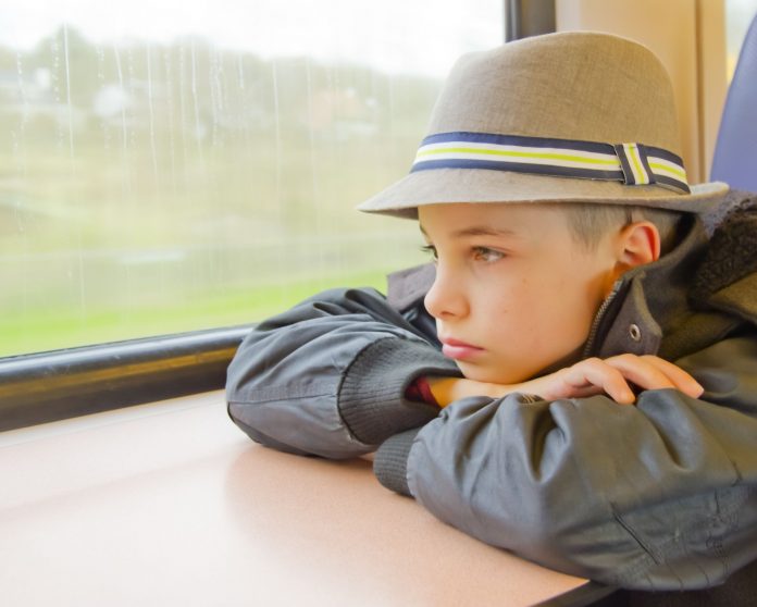 18992270 - boy rides on a train and looking out the window.