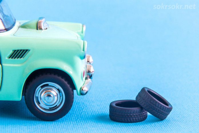 Car toy with two tires. Auto repair abstract. Space for copy.